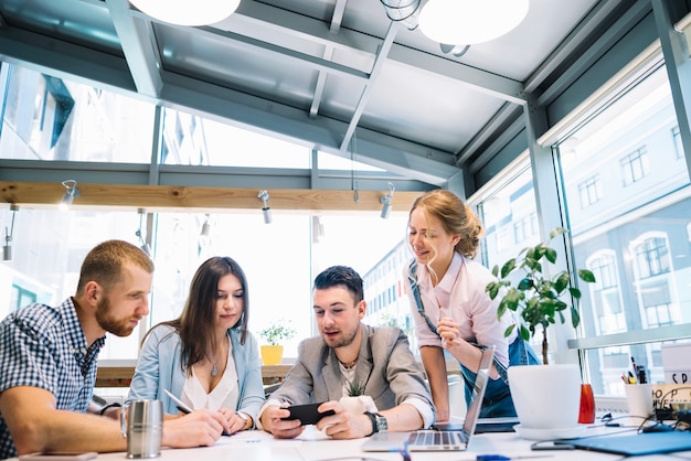 Photo gratuite personnes utilisant un téléphone sur le lieu de travail