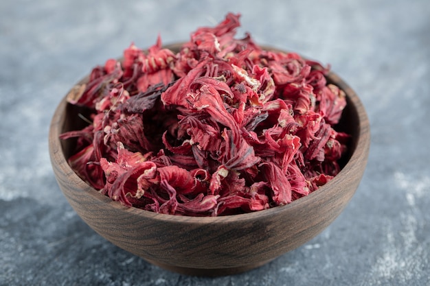 Pétales d'hibiscus secs dans un bol en bois.