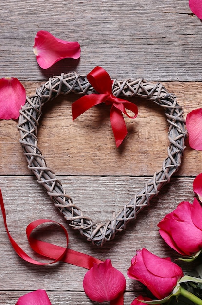 Pétales de rose avec cadre en forme de coeur