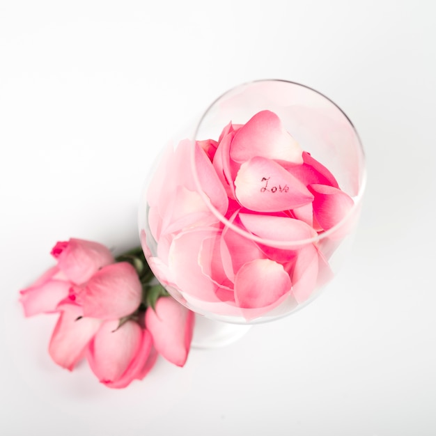 Pétales de roses roses en verre sur table