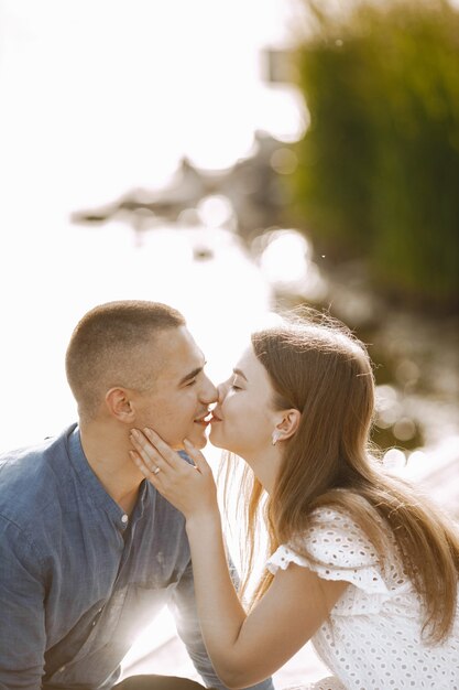 Petit ami et petite amie de couple romantique s'embrassant près du lac. Homme et femme se regardant et s'embrassant