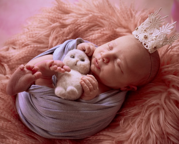Photo gratuite le petit bébé avec une couronne se trouve dans le panier