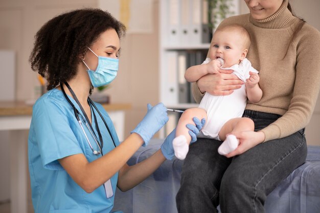 Petit bébé étant à la clinique de santé pour la vaccination