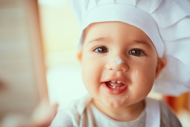 Le petit bébé jouant avec de la farine