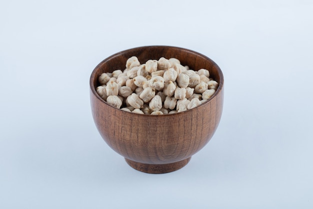 Un petit bol en bois plein de haricots blancs crus