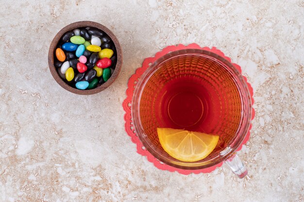 Un petit bol de bonbons assortis et une tasse de thé