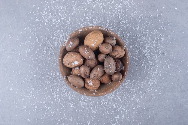 Petit bol de noix assorties sur une surface en marbre