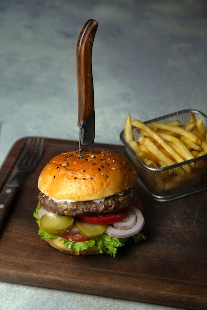 Petit burger de bœuf aux cornichons concombre, oignon, laitue, tomate servi avec frites