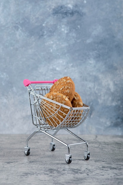 Un Petit Chariot Rose Avec Des Biscuits à L'avoine Sains Placés Sur Une Table En Pierre.