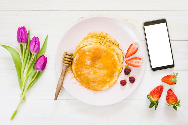 Petit déjeuner aux crêpes avec téléphone portable