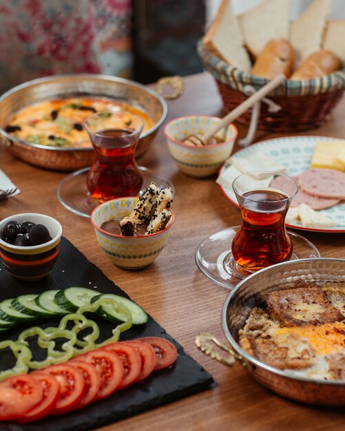 Petit déjeuner avec divers plats et thé noir