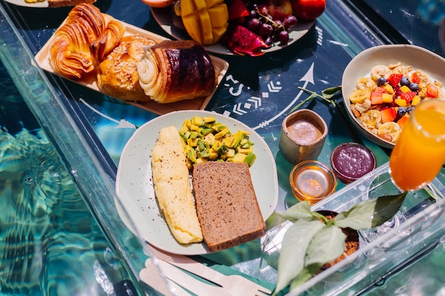 Photo gratuite petit-déjeuner flottant dans une incroyable villa d'hôtel dans la piscine bleue