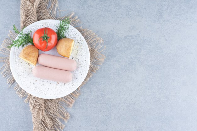 Petit-déjeuner frais. Saucisse bouillie avec tomate et pomme de terre.