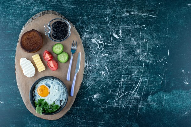 Petit déjeuner avec œuf au plat, caviar et légumes. photo de haute qualité