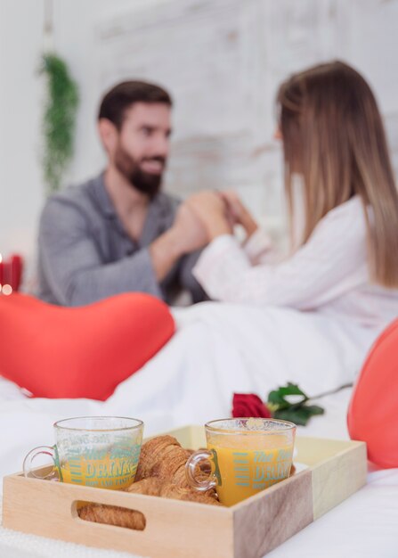 Petit-déjeuner romantique sur un plateau en bois sur le lit