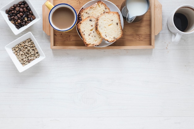 Photo gratuite petit-déjeuner sain avec des grains de café et du pain dans un plateau