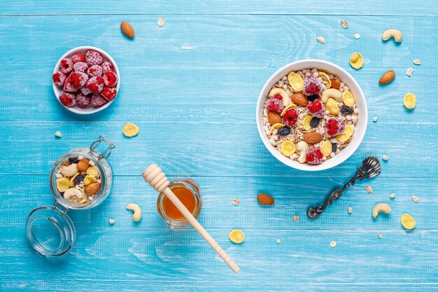 Petit-déjeuner sain. Granola frais, muesli aux noix et baies surgelées. Vue de dessus. Copiez l'espace.