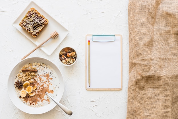 Petit-déjeuner sain avec presse-papiers et crayon sur fond blanc