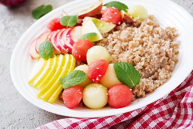 Petit-déjeuner sain. Sarrasin ou bouillie au melon frais, pastèque, pomme et poire. Nourriture savoureuse.