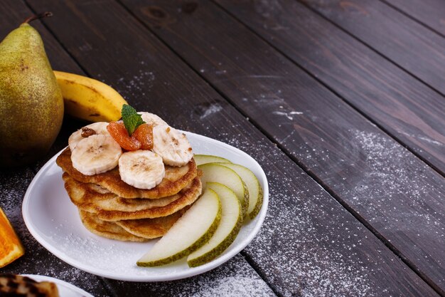 Petit-déjeuner savoureux. Délicieuses crêpes recouvertes de chocolat, de cerises, de bananes et de poires