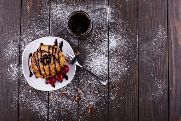 Petit-déjeuner savoureux. Délicieuses crêpes recouvertes de chocolat et de cerises