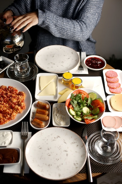 Photo gratuite petit déjeuner à la tomate avec des œufs, des saucisses, etc.