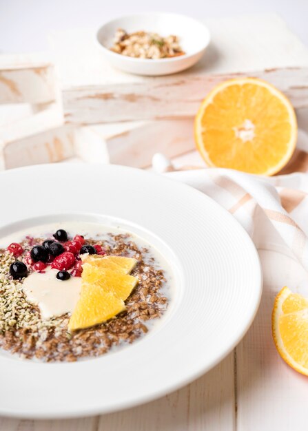 Petit déjeuner avec des tranches d'orange et des graines haute vue