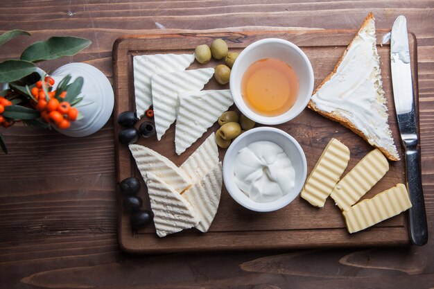 Petit-déjeuner vue de dessus avec fromage et olive et miel dans une batterie de cuisine