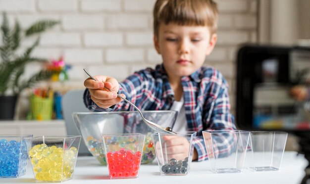 Photo gratuite petit enfant avec des boules d'hydrogel