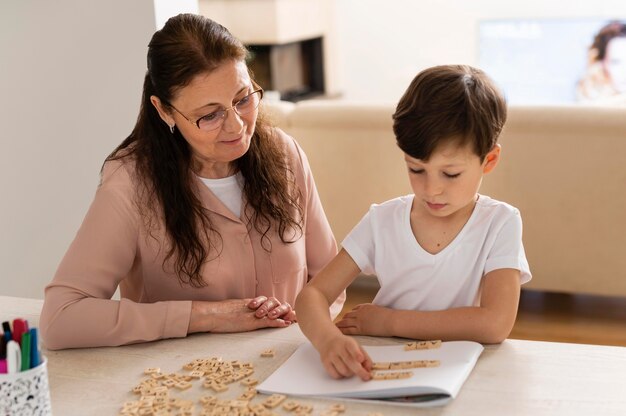 Petit-enfant à faire ses devoirs avec grand-mère