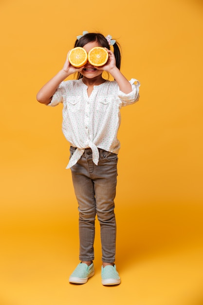 Petit enfant fille couvrant les yeux avec orange.