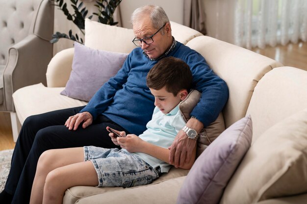 Petit-enfant et grand-père se détendre sur le canapé