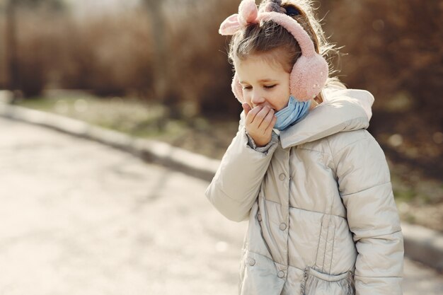 Petit enfant marche dehors dans un masque