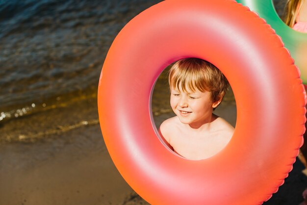 Petit enfant tenant un anneau de natation gonflable