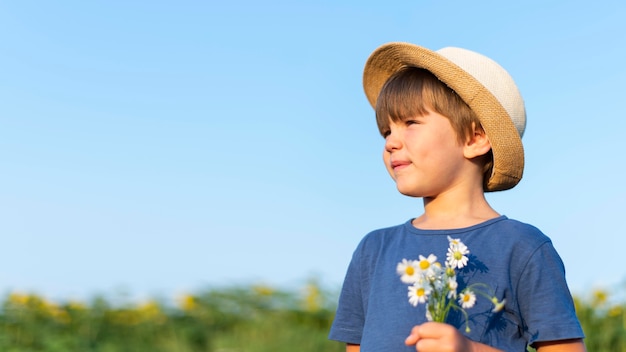 Petit enfant tenant des fleurs