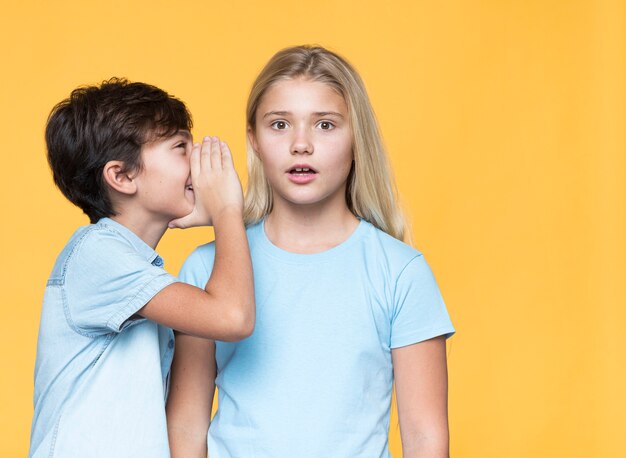 Petit frère chuchotant un secret à sa sœur