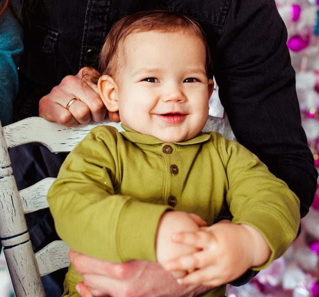 Le petit garçon assis sur la chaise