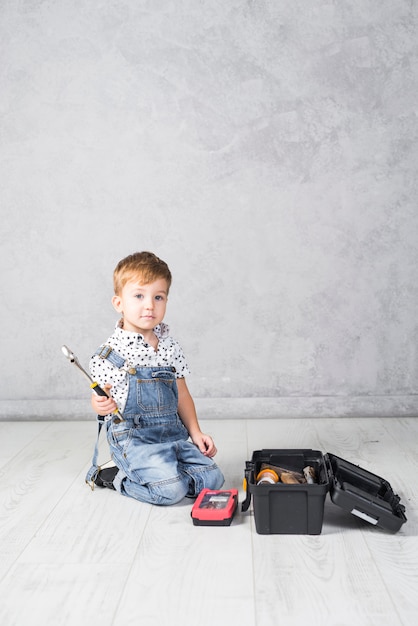 Photo gratuite petit garçon assis avec une clé