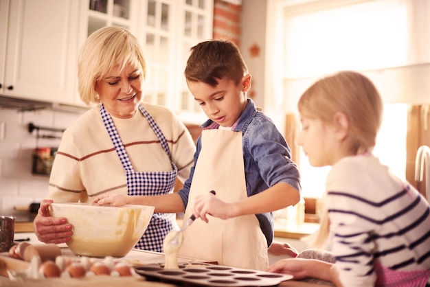 Photo gratuite petit garçon cuisant entre dames