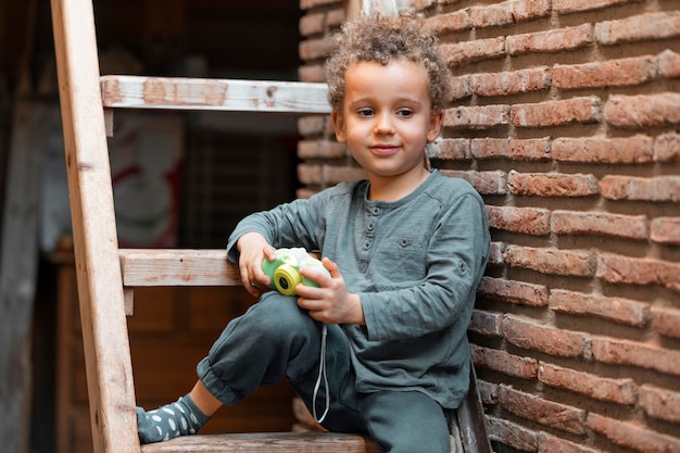 Petit garçon à l'extérieur avec jouet appareil photo