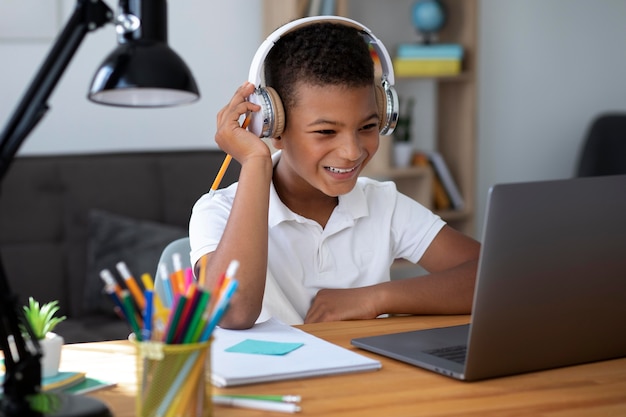 Petit garçon faisant l'école en ligne