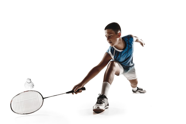 Petit garçon jouant au badminton isolé sur blanc.