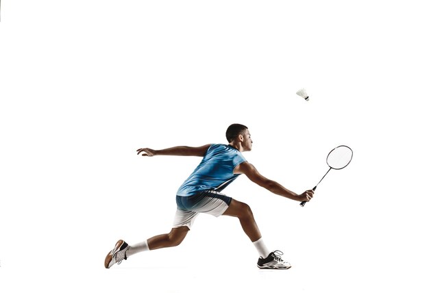 Petit garçon jouant au badminton isolé sur fond blanc.