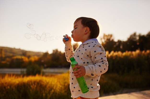 Petit garçon jouant avec des bulles de savon