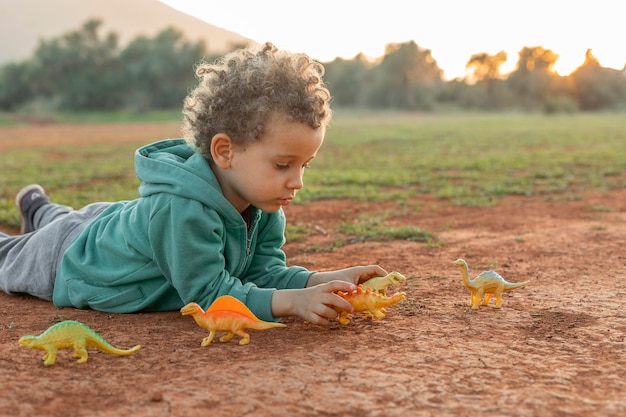 Petit garçon jouant à l'extérieur avec des jouets
