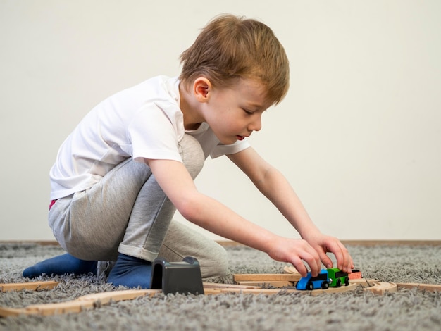 Photo gratuite petit garçon jouant avec le jeu de voiture