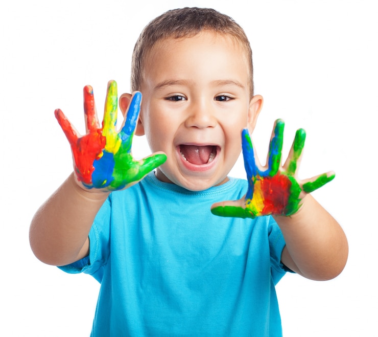 Photo gratuit petit garçon avec les mains pleines de peinture et avec la bouche ouverte