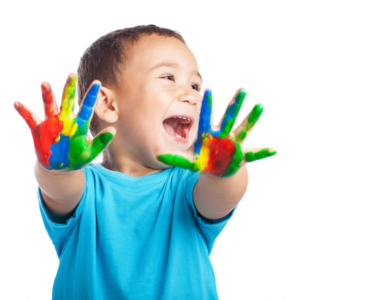 Photo gratuit petit garçon avec les mains pleines de peinture et avec la bouche ouverte