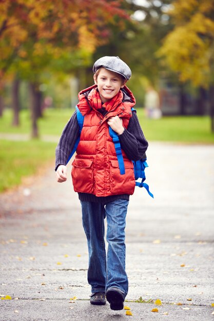 Petit garçon marchant à l&#39;école avec sac à dos