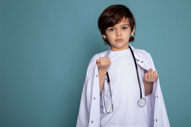 Petit garçon mignon adorable doux en combinaison médicale blanche sur bleu